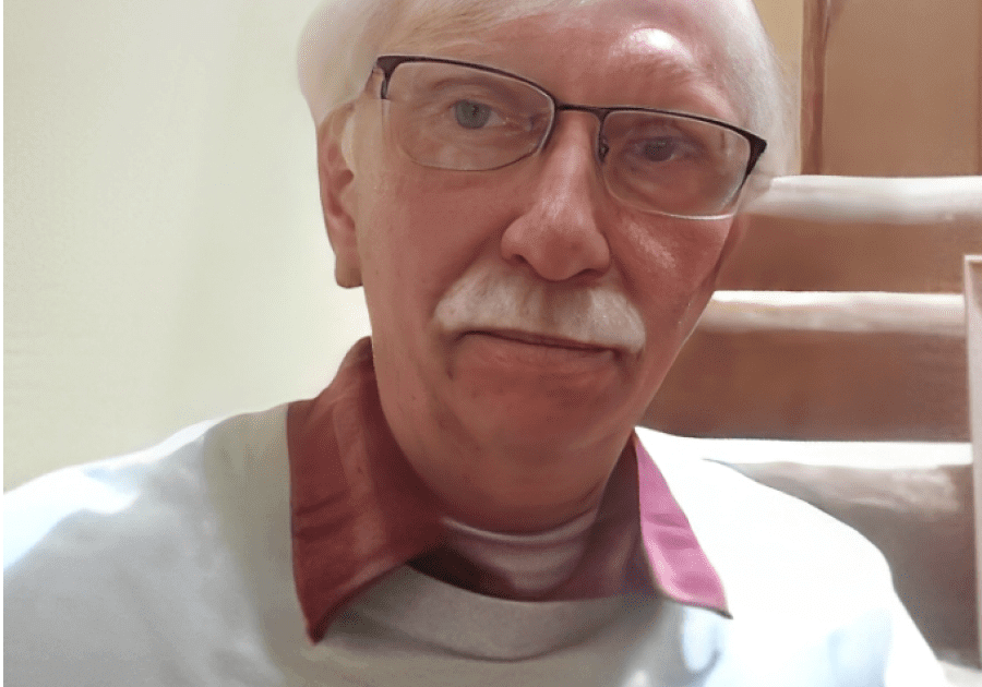 Elderly man wearing glasses and white mustache.