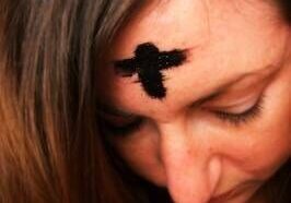 Woman with ash cross on forehead.