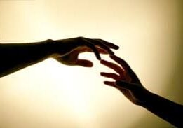 Two hands reaching towards each other.