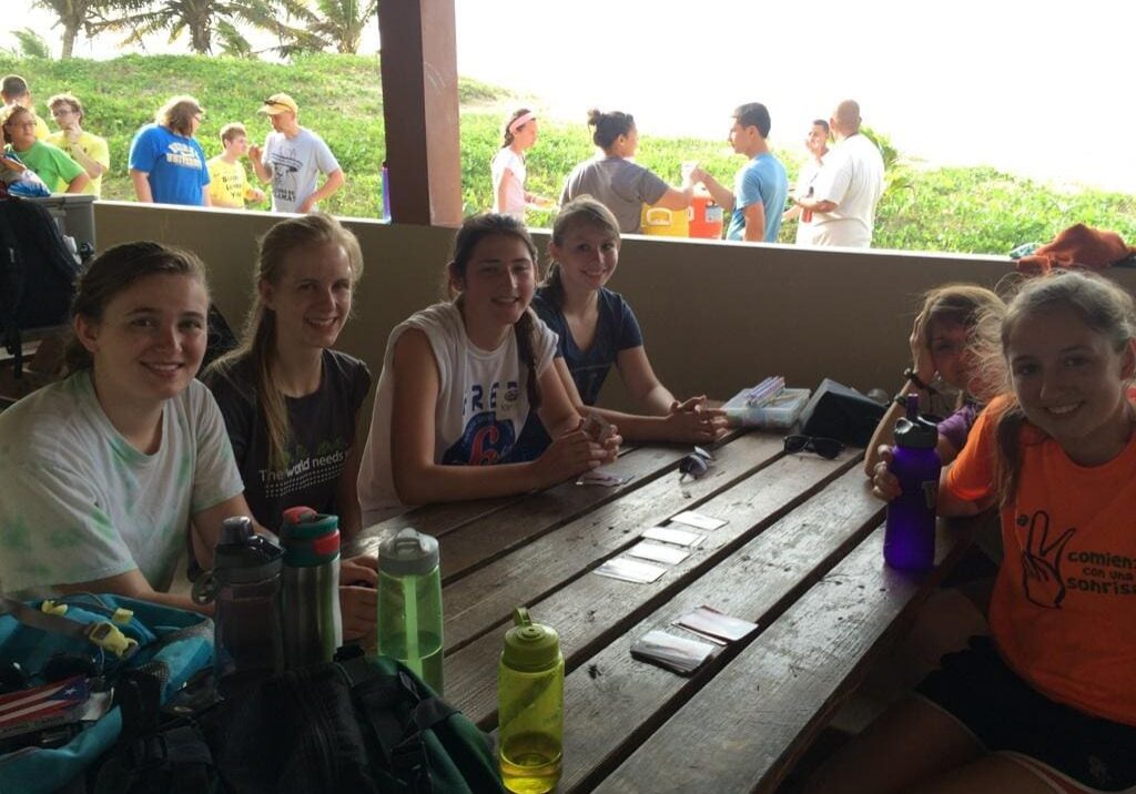 Teens sitting at picnic table outdoors